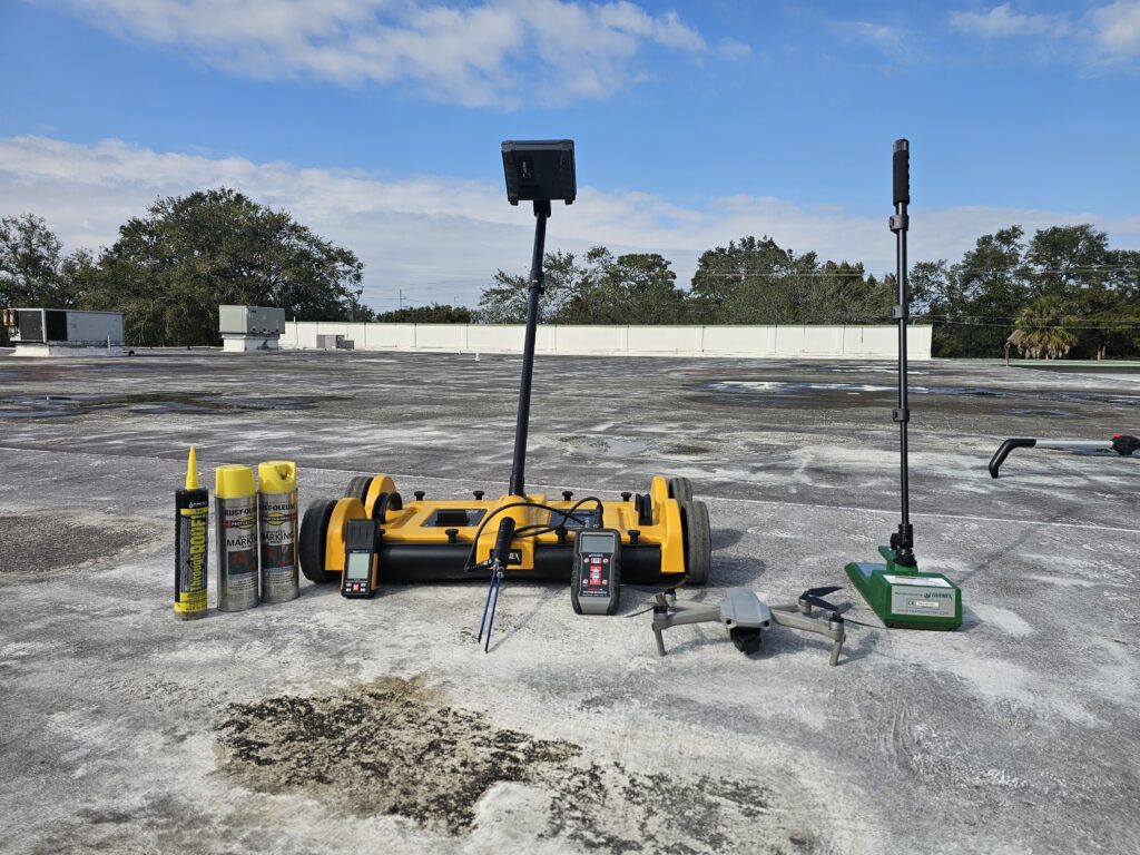 Technician performing impedance moisture scanning on a commercial flat roof in Tampa